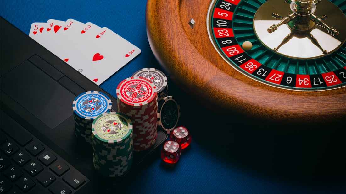 Chip kasino berwarna warni tersusun di dekat roda roulette